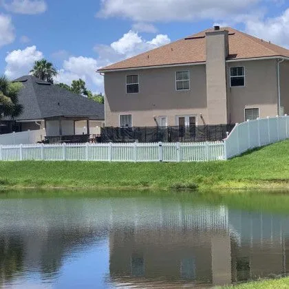 White vinyl fencing along the rear of homes backing onto a retention pond