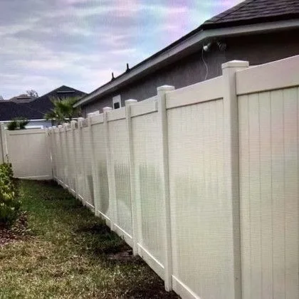 White vinyl privacy fence running the length of a residential back yard