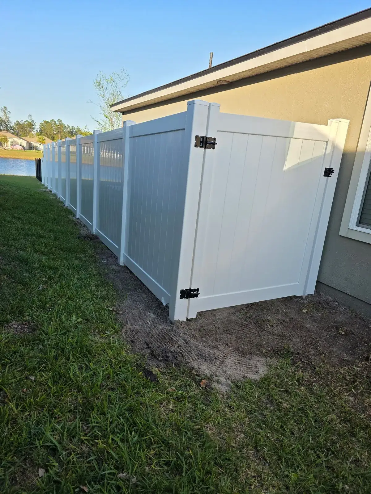 White vinyl fence with a double gate for equipment access