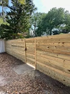 Wood fence and gate closing off a gravel side yard access path