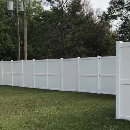 White vinyl privacy fence installed across a level back yard
