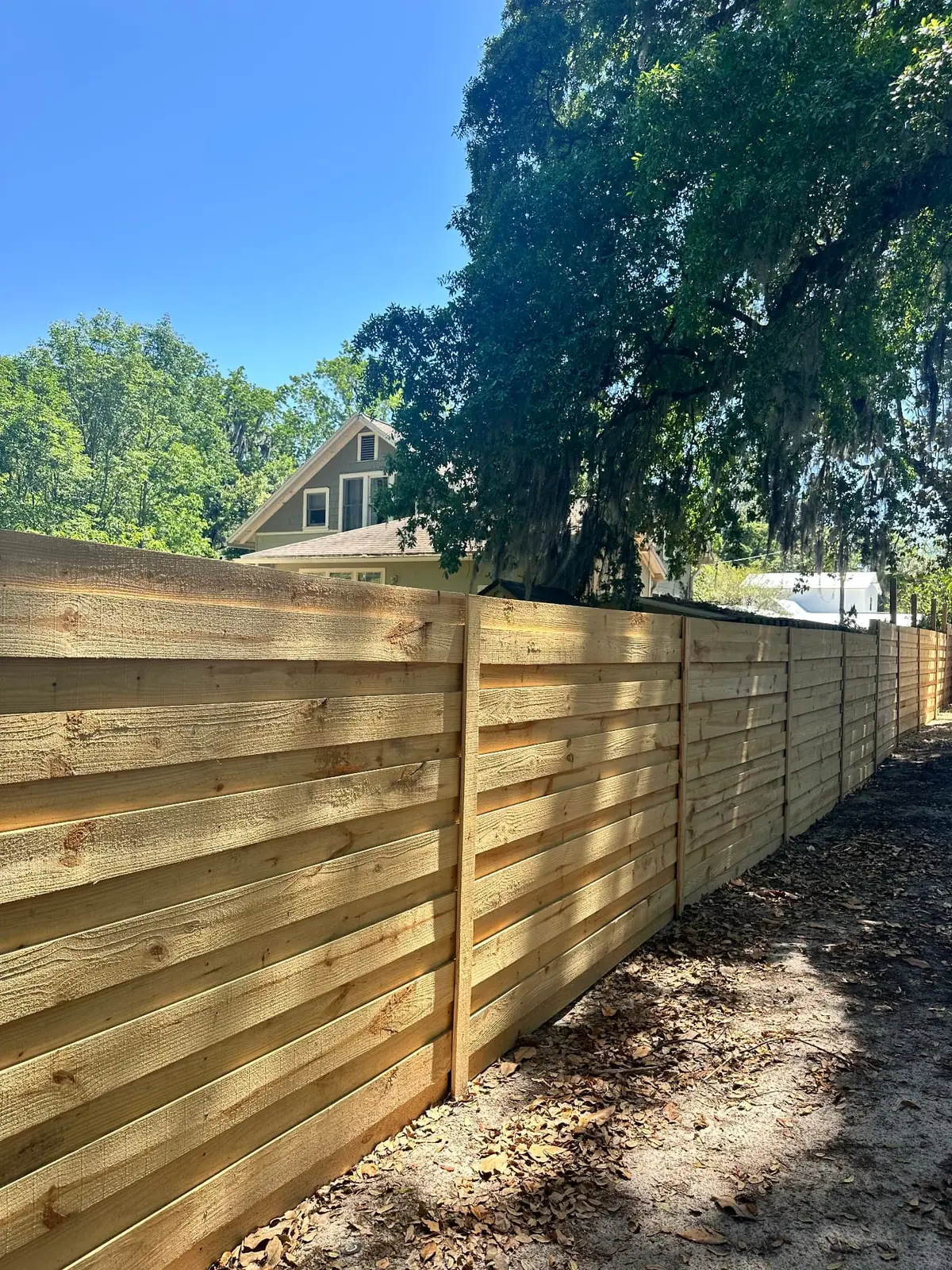 Horizontal wood privacy fence following a shaded residential property line